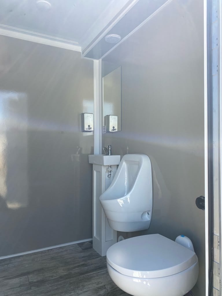 Clean running-water sink and porcelain fixtures inside Day Break Sanitation restroom fleet